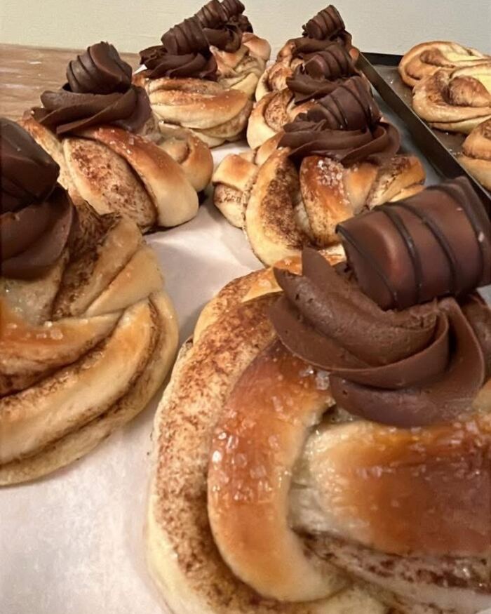 Boller med sprøytet sjokoladekrem og en bit sjokolade på toppen.